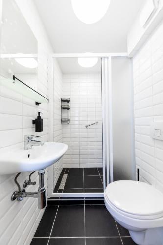 a white bathroom with a toilet and a sink at Adagio Downtown Rooms in Budapest