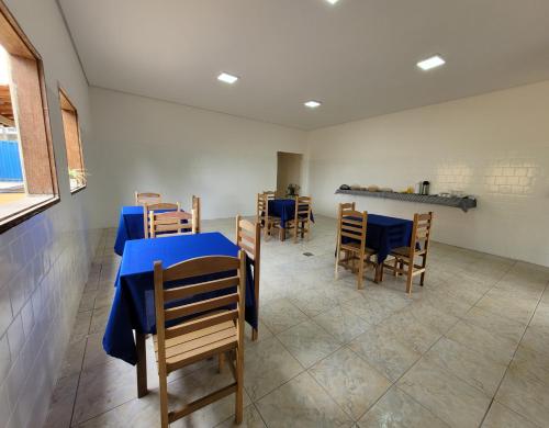 uma sala de jantar com uma mesa azul e cadeiras em Canastra Eco Hospedagem em São Roque de Minas