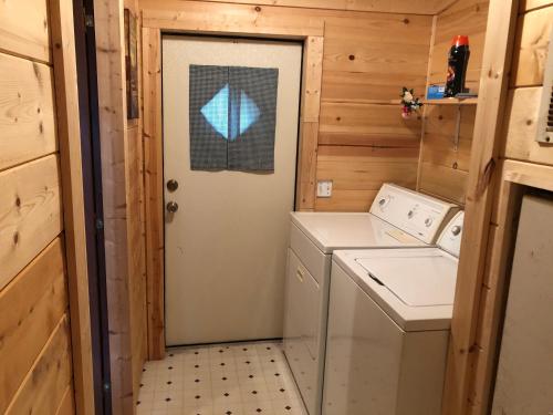 a door to a washer and dryer in a tiny house at Twin Oaks in Bryson City