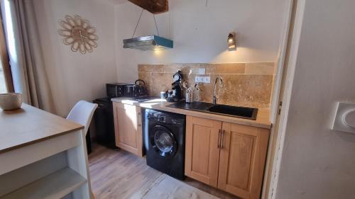 une cuisine avec un évier et une machine à laver dans l'établissement Studio avec beaucoup de Charme intra muros, à Avignon