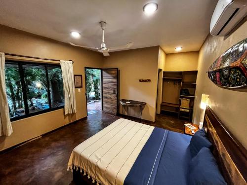 a bedroom with a bed and a large window at Hotel Gallo de Mar in Puerto Escondido