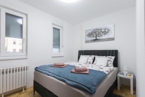 um quarto com uma cama com duas almofadas em Apartman Lariva em Osijek
