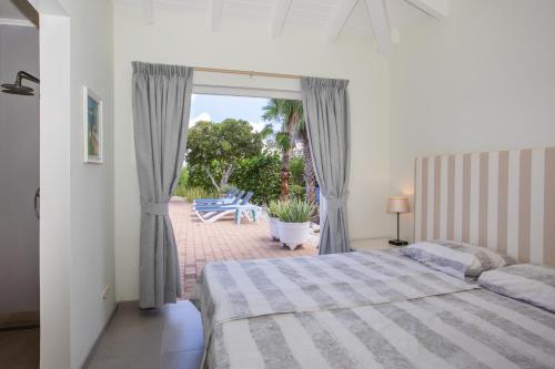a bedroom with a bed and a view of a patio at Villa Caribbean Passion in Willibrordus
