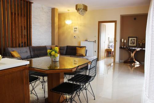 Elegant View - Trikala - 3BD Apt في تريكالا: مطبخ وغرفة معيشة مع طاولة وأريكة