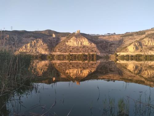 um reflexo de uma montanha na água em R U Ready Fishing, River Ebro em Mequinenza