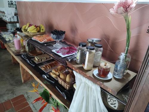 uma mesa com um buffet de comida em Pousada Zimbauê em Itaúnas