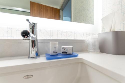 uma casa de banho com um lavatório com uma torneira e duas chávenas em Holiday Inn Express & Suites - Chilliwack East an IHG Hotel em Chilliwack