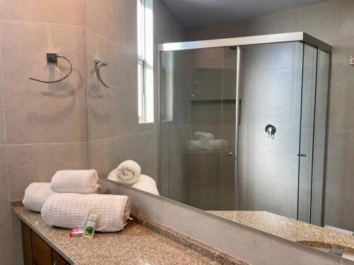 a bathroom with a shower and a sink with towels at Deluxe Department in Cochabamba