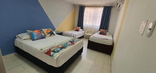 a small room with two beds and a window at Vivienda Turística Colon in San Andrés