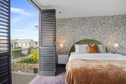 a bedroom with a large bed and a large window at Central High-end 3BR Home in Parnell with Pool in Auckland