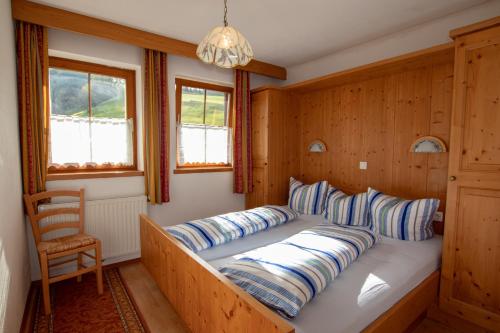 a bedroom with a bed with a wooden wall at Ferienwohnung zum Mühltal WILD025 in Wildschönau