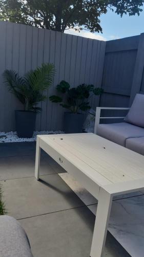 a white coffee table on a patio with a couch at 3 bedroom townhouse in Liverpool