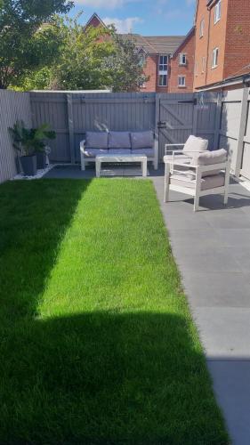 a yard with two benches and a grassy lawn at 3 bedroom townhouse in Liverpool