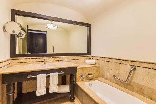 a bathroom with a tub and a sink and a mirror at Grand Fiesta Americana Los Cabos All Inclusive Golf & Spa in Cabo San Lucas