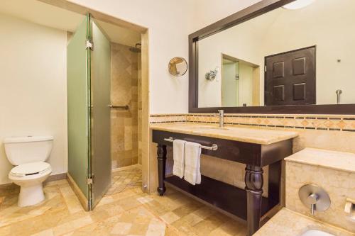 a bathroom with a sink and a toilet and a mirror at Grand Fiesta Americana Los Cabos All Inclusive Golf & Spa in Cabo San Lucas
