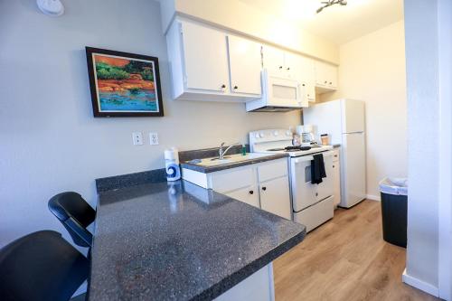 a small kitchen with a sink and a refrigerator at Venture on Country Club in Mesa
