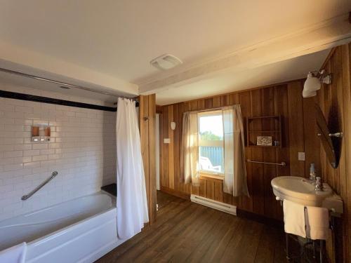 La salle de bains est pourvue d'une baignoire et d'un lavabo. dans l'établissement Maison Victoria, à La Malbaie