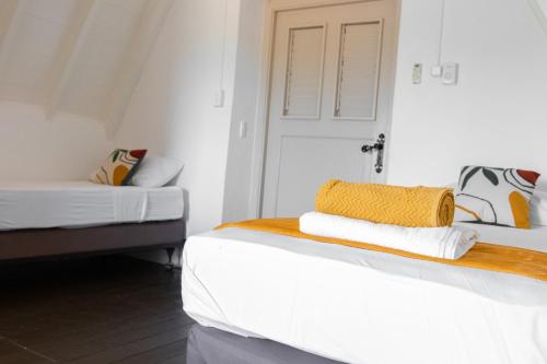 a room with two beds and a door and a room with at Landhuis Daniel - Plantation House in Tera Kora