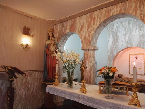 a room with a table with flowers and a mirror at Villa Sacro Cuore in San Giovanni Rotondo