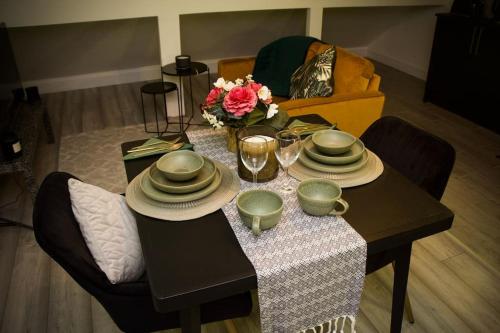 uma mesa de jantar com pratos e flores em 1 Bed Apartment B em Birmingham