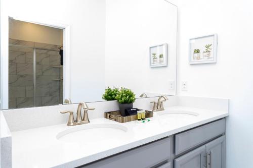 a white bathroom with two sinks and a mirror at Wonderful 8Bd7BA Melbourne Beach w Pool Dock & Beach in Melbourne Beach