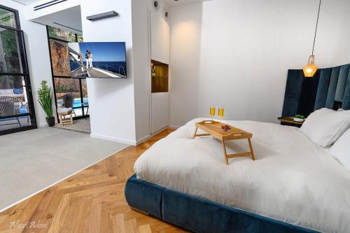 1 dormitorio con 1 cama grande y 1 mesa en סוויטת הרמס- סוויטת פאר עם בריכת שחיה פרטית, en Safed