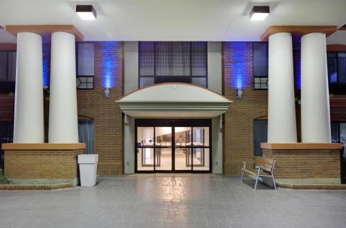 un edificio con columnas y una puerta con silla en Holiday Inn Express Hotel & Suites Burleson - Fort Worth, an IHG Hotel, en Burleson