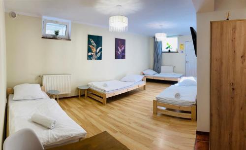 een kamer met drie bedden in een kamer bij Hostel Dalia in Zielona Góra