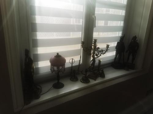 a window with a bunch of antiques in a window sill at Appartement Mayolles in Épinal
