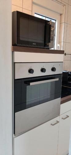 a microwave sitting on top of a stove in a kitchen at Blue Lagoon in Nehren