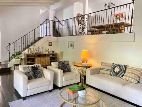 a living room with two couches and a staircase at Entire villa on Sunset Strip in Los Angeles