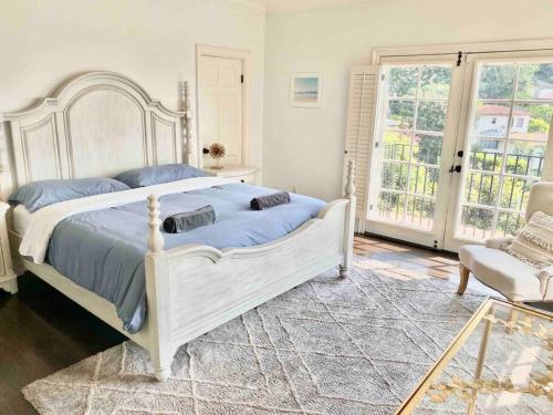 a bedroom with a large white bed and a chair at Entire villa on Sunset Strip in Los Angeles