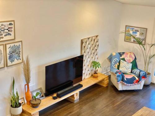 a living room with a flat screen tv and a chair at Entire villa on Sunset Strip in Los Angeles
