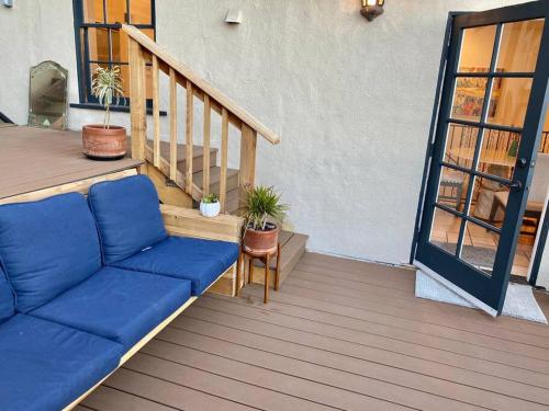 a blue couch sitting on a porch with a staircase at Entire villa on Sunset Strip in Los Angeles
