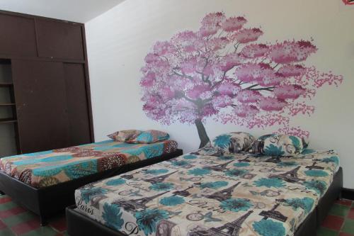 ein Schlafzimmer mit 2 Betten und einem Baum an der Wand in der Unterkunft Casa en Honda La Casa de Flor en el barrio Guali in Honda