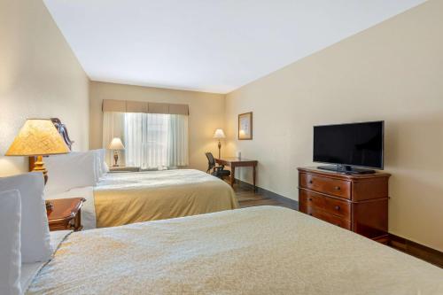 a hotel room with two beds and a flat screen tv at Best Western PLUS Fossil Country Inn & Suites in Kemmerer