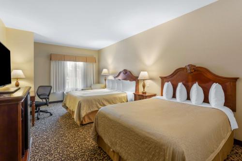 Best Western PLUS Fossil Country Inn & Suites في Kemmerer: غرفه فندقيه سريرين وتلفزيون