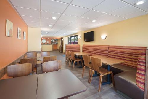 a restaurant with tables and chairs and a tv at Best Western Inn in Goshen