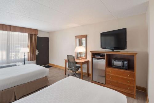 a hotel room with two beds and a flat screen tv at Best Western Inn in Goshen
