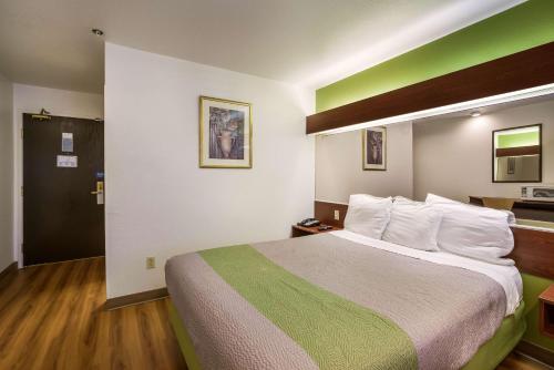 a large bed in a hotel room with a green and white at Motel 6-Dixon, CA in Dixon