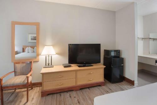 a room with a television on a dresser with a bed at Best Western Inn in Goshen