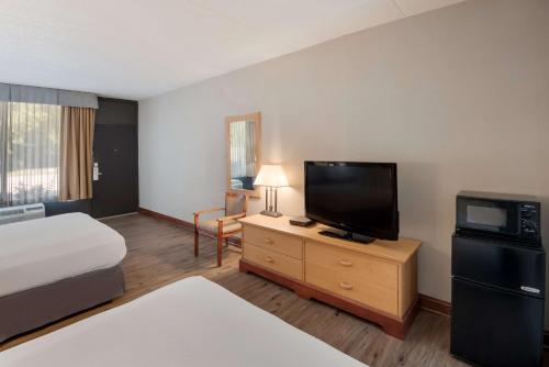 a hotel room with a bed and a flat screen tv at Best Western Inn in Goshen