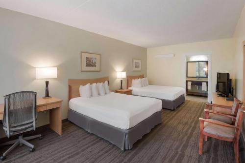 a hotel room with two beds and a desk at Best Western Inn in Goshen