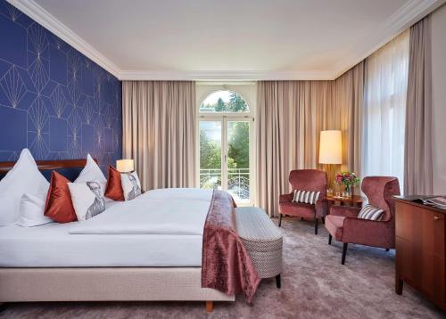 a bedroom with a large bed and a window at Maison Messmer - ein Mitglied der Hommage Luxury Hotels Collection in Baden-Baden