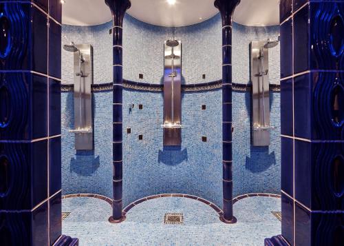 La salle de bains est revêtue de carrelage bleu. dans l'établissement Maison Messmer - ein Mitglied der Hommage Luxury Hotels Collection, à Baden-Baden