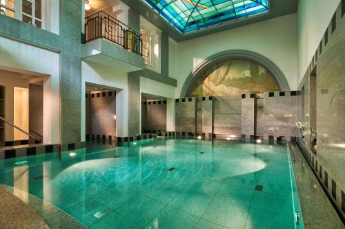 ein großer Pool in einem Gebäude mit Buntglasfenster in der Unterkunft Maison Messmer - ein Mitglied der Hommage Luxury Hotels Collection in Baden-Baden