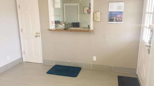 a hallway with a mirror and a blue rug at Motel 6 Newport News, VA – Fort Eustis in Newport News