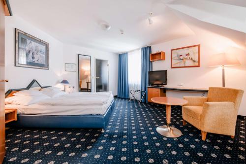 ein Hotelzimmer mit einem Bett, einem Schreibtisch und einem Stuhl in der Unterkunft Hotel Empfinger Hof, Sure Hotel Collection by Best Western in Empfingen