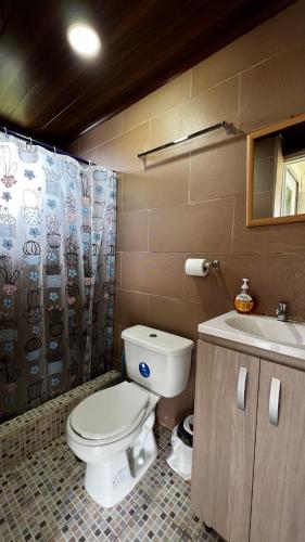 a bathroom with a toilet and a sink at Sol y Luna Pedasí in Pedasí Town
