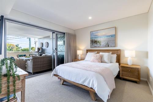 a bedroom with a bed and a living room at Footprints 1 in Fingal Bay